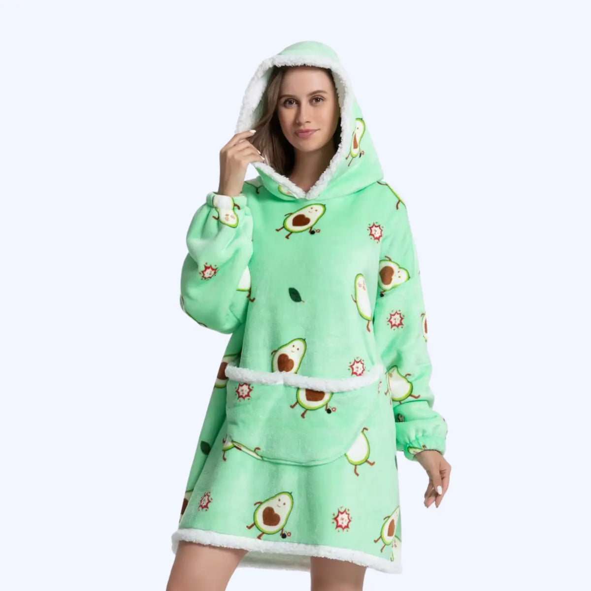 Woman wearing a hoodie blanket with avocado pattern and a sherpa-lined hood and pocket. 