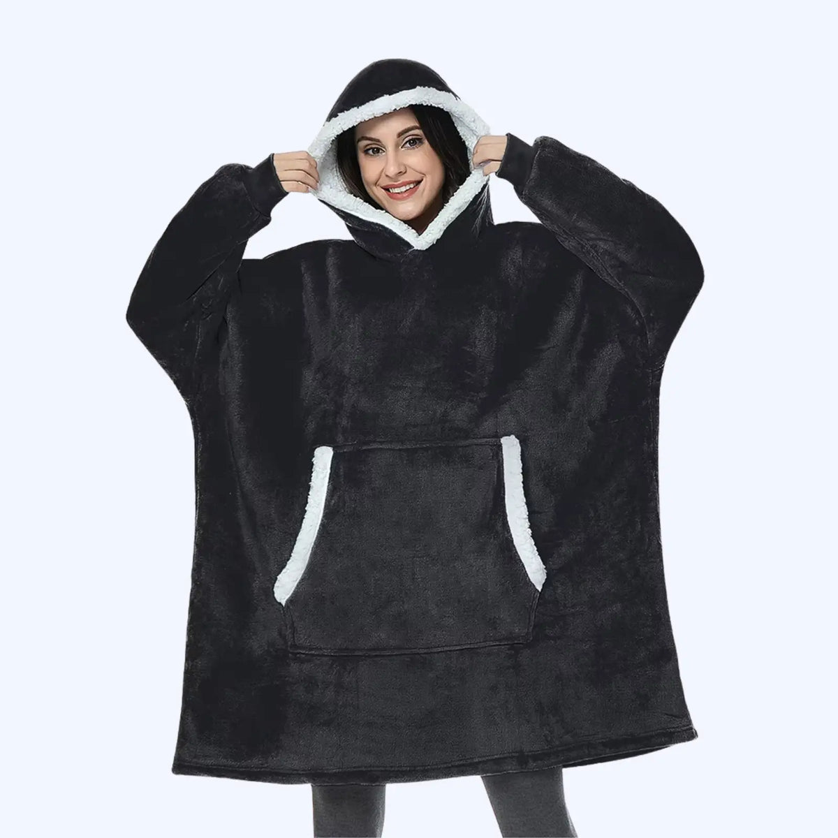 Woman wearing a black hoodie blanket with sherpa-lined hood and pocket. 