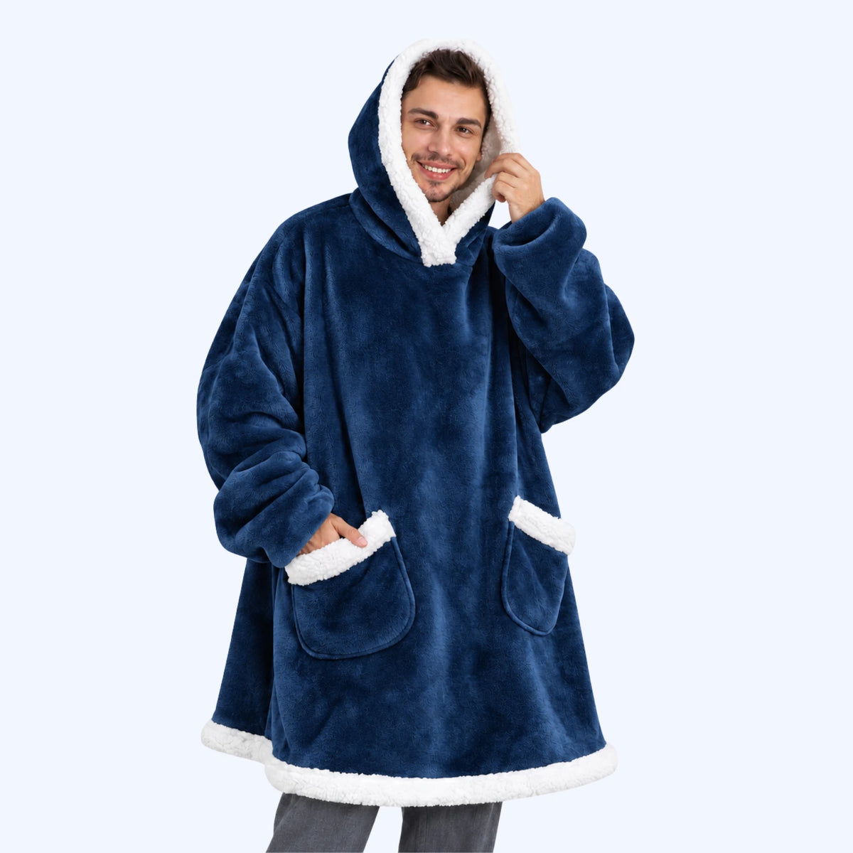 A man wearing a navy blue hoodie blanket with white sherpa lining and two pockets. 