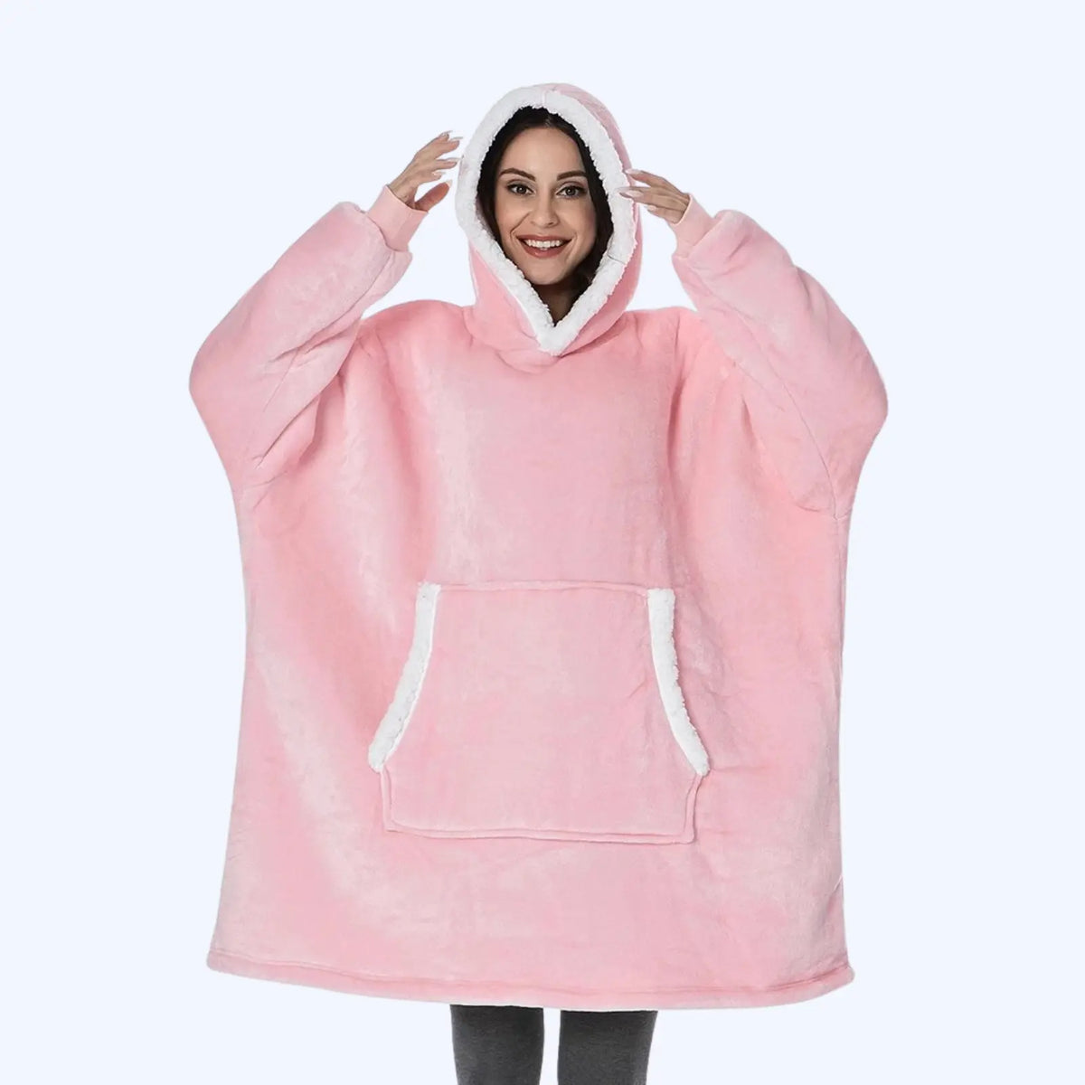 Woman wearing a pink hoodie blanket with sherpa-lined hood and pocket. 
