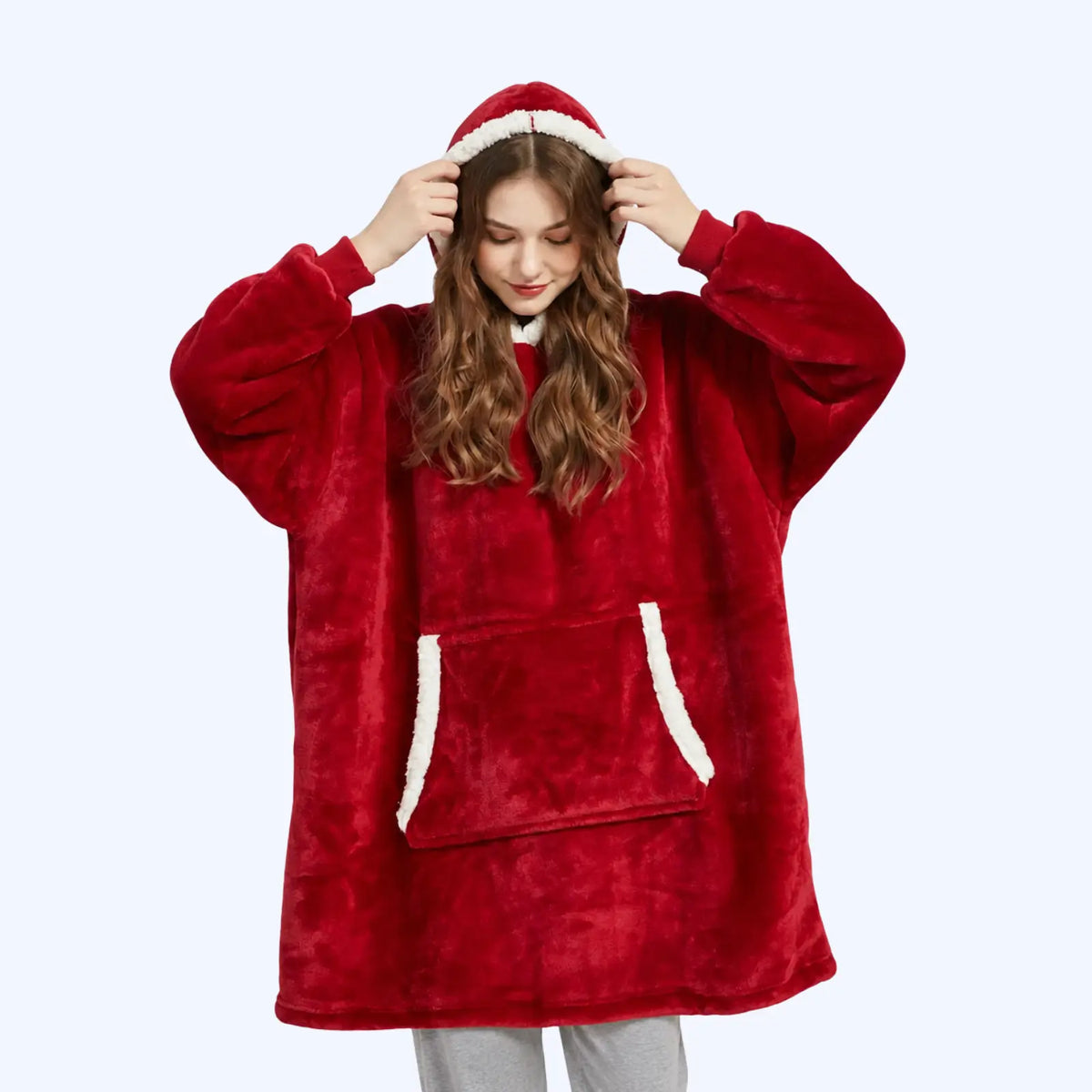 Woman wearing a red hoodie blanket with sherpa-lined hood and pocket. 