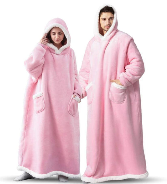 Woman and man wearing pink extra long blanket hoodies that cover from head to toe. 